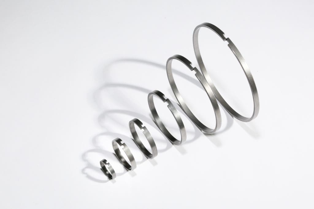 Step gap piston plunger wear rings for die casting machines